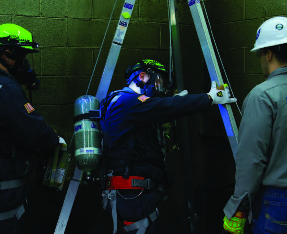 Three workers performing a rescue in a confined underground space